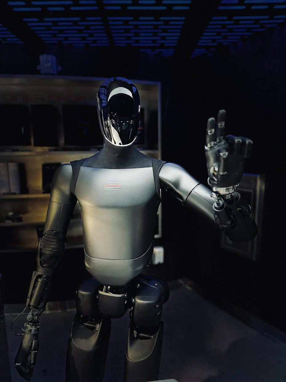 Tesla's Optimus humanoid robot raising a hand